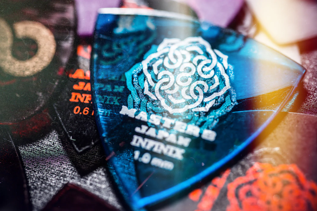 Master 8 Japan INFINIX guitar pick in blue finish with printed logo and 1.0mm thickness marking.