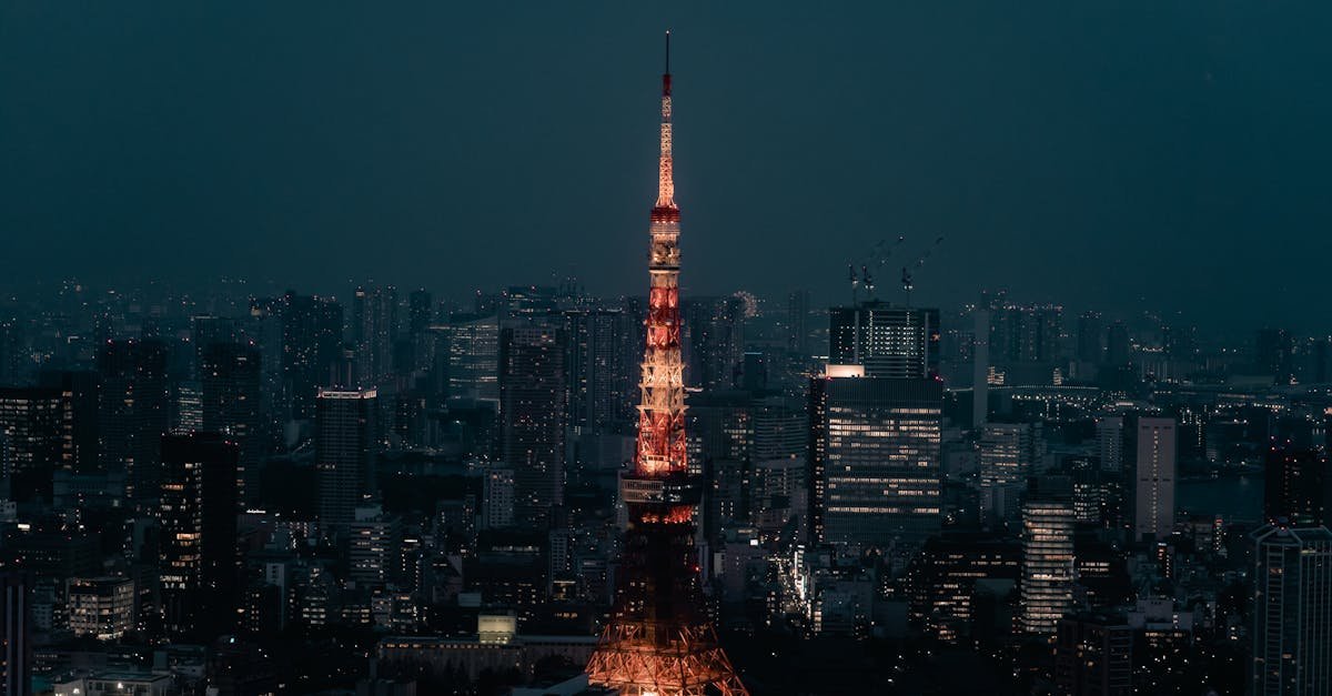 Stunning view of Tokyo Tower lit up at night, surrounded by the urban skyline of Minato City, Tokyo.