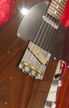 Close-up of the brass 3-saddle bridge on a Fender Japan TL69-115 Rosewood Telecaster.