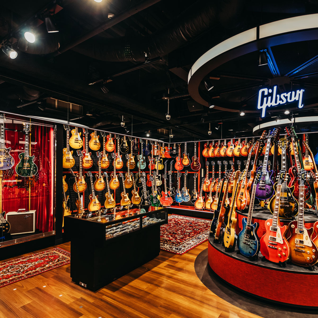 Interior of an Ikebe Gakki guitar showroom with Gibson guitars on display
