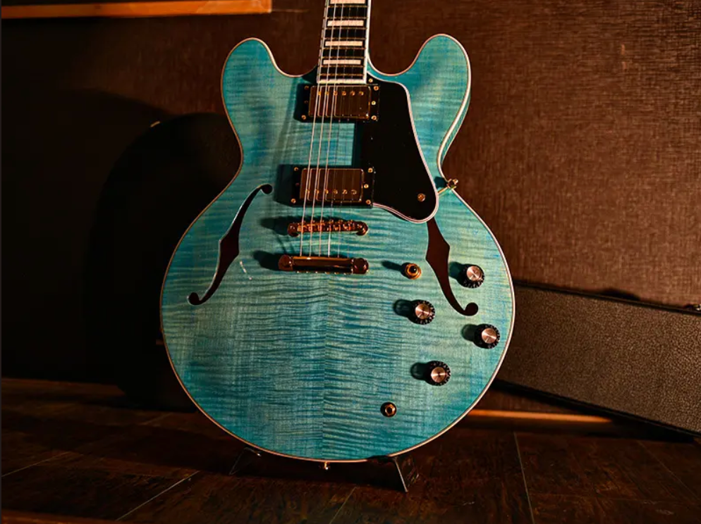 A Seventy Seven semi-hollow guitar in blue flamed maple, one of Deviser's brands