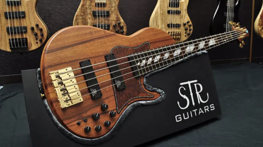 An STR Guitars custom-built boutique bass with a figured wood top at the STR Guitars display
