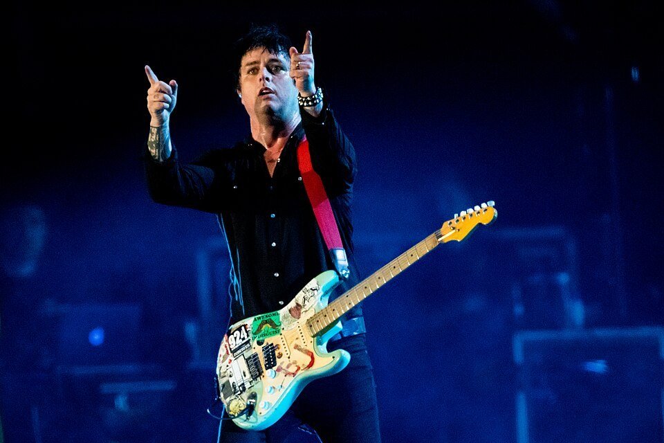 Billie Joe Armstrong of Green Day on stage with his sticker-covered blue Strat